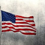 American flag waving in front of distressed black and white background