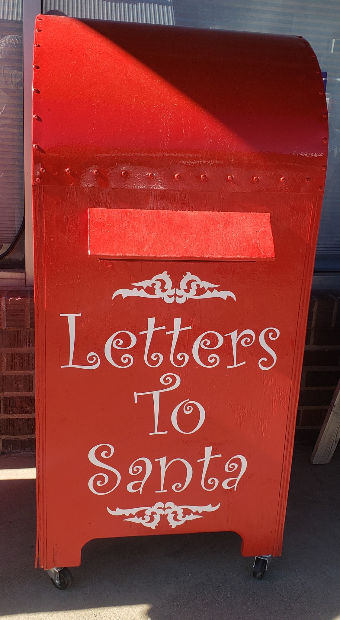 Image of a large red letter box. On the front there is a slot for letters to be deposited. In white text the mail box reads "Letters to Santa"